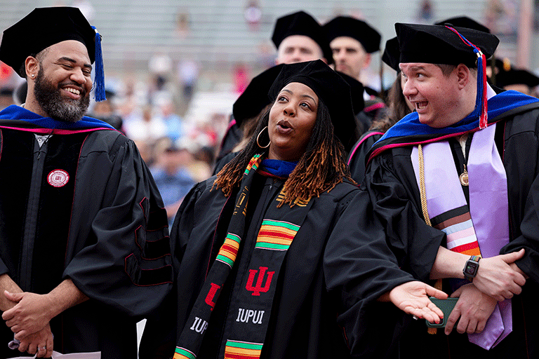 Three graduates singing during the graduate ceremony