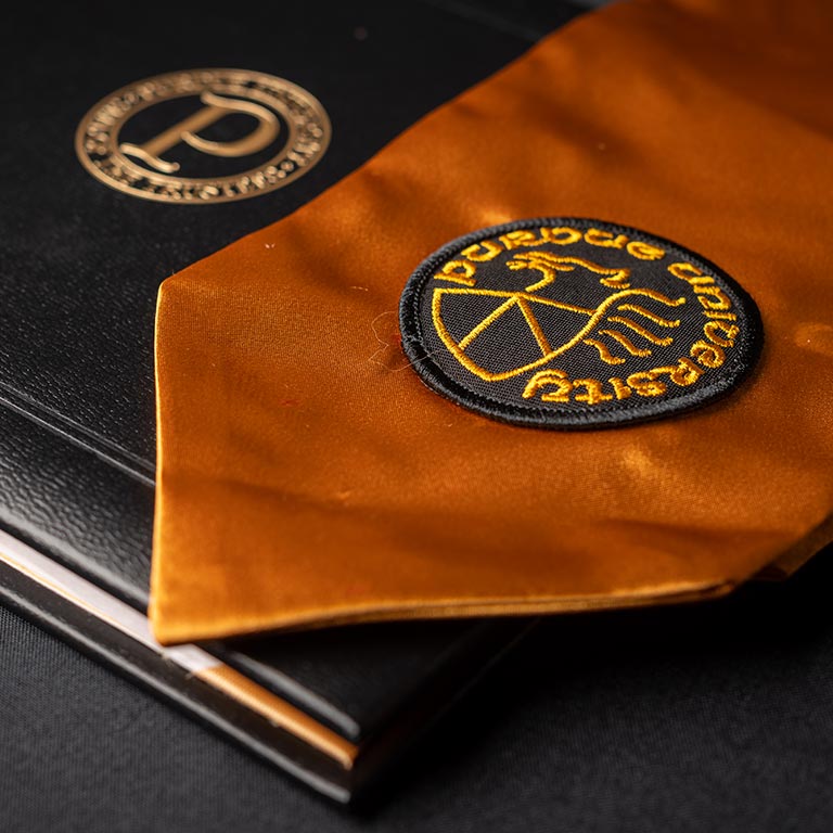 Gold Purdue sash and black Purdue diploma cover